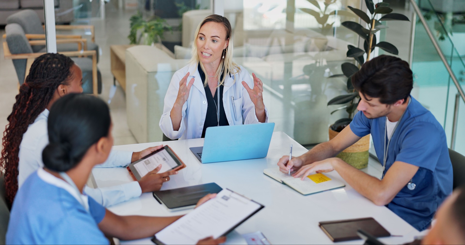 Doctors, teamwork and discussion for healthcare in office with technology, documents and research. Collaboration, group and nurses in boardroom for health meeting or brainstorming medical information